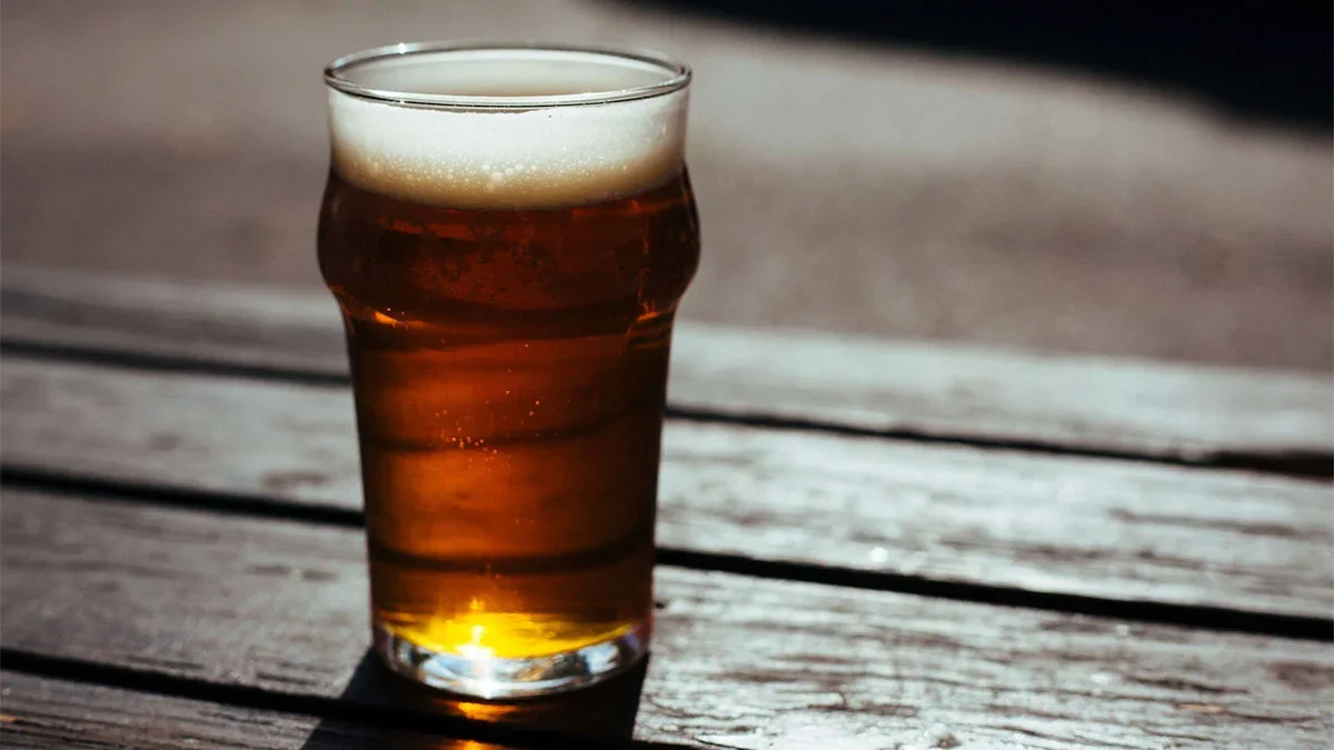 glass of beer on table in sun